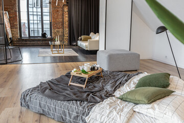 minimalist stylish interior of white simple bedroom with window in ceiling and sun rays without people