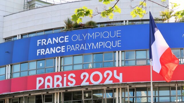 "France olympique / France paralympique / Paris 2024" inscrit sur la fa&ccedil;ade de la Maison du Sport Fran&ccedil;ais, pour les Jeux olympiques (JO) d'&eacute;t&eacute; 2024, avec un drapeau fran&ccedil;ais &ndash; mai 2023 (France)