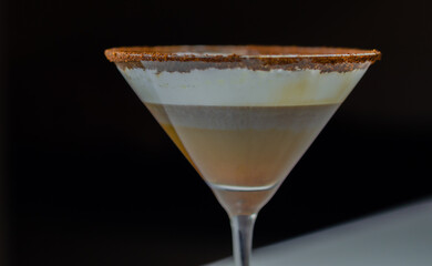 A chocolate martini is poured into a martini glass