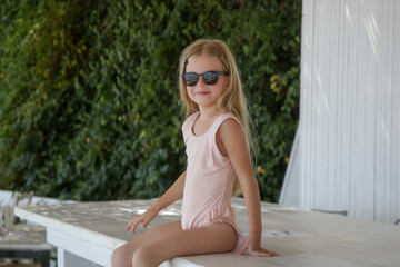 Portrait of adorable little girl enjoying summer vacation in the beach bar