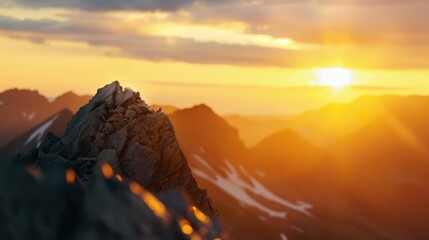 Majestic mountain peak bathed in golden sunset light with distant mountain ranges and a serene sky