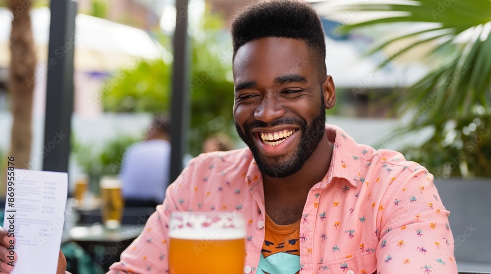 Poster a man is sitting at a table with a beer in his hand and a smile on his face. he is holding a menu an
