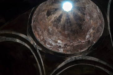 The interior of a dome with a central oculus that allows natural light to filter through at Sanahin Monastery Complex in the Lori Province of Armenia