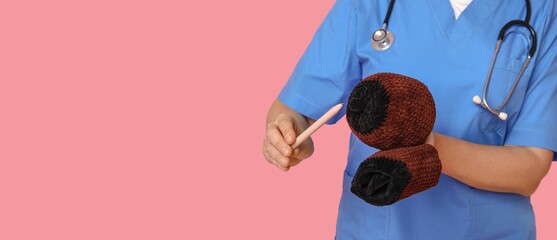Doctor with knitted model of female breast and human mouth on pink background with space for text....