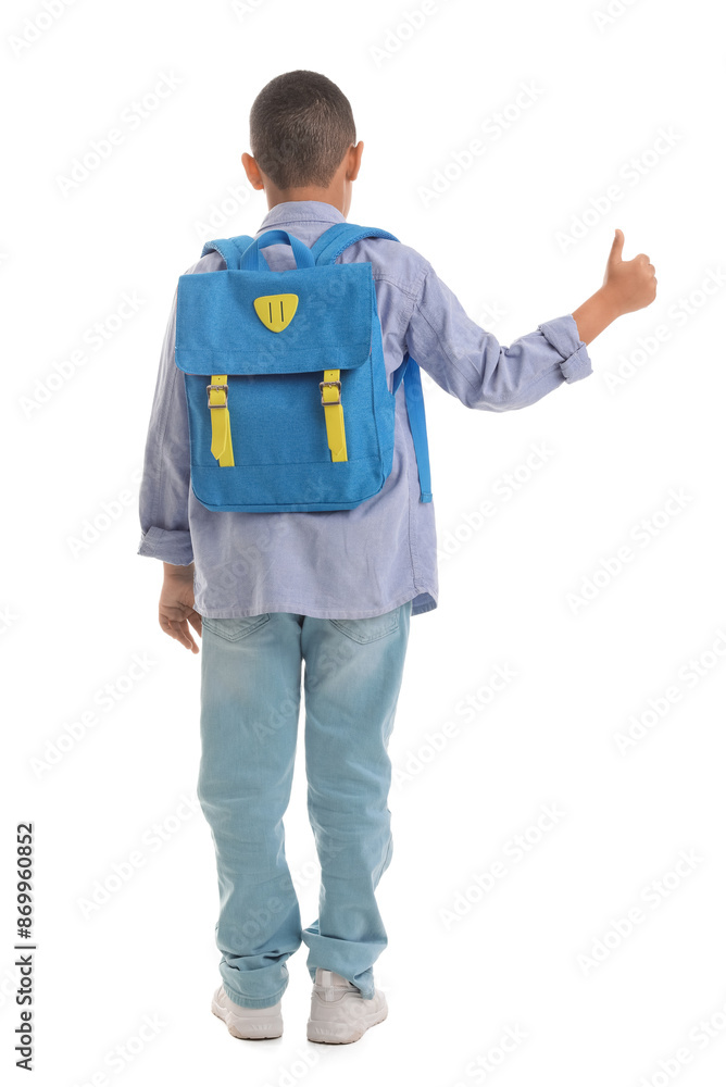 Wall mural Little African-American schoolboy with backpack showing thumb-up on white background, back view