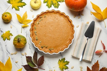 Autumn composition with tasty pumpkin pie on white marble background