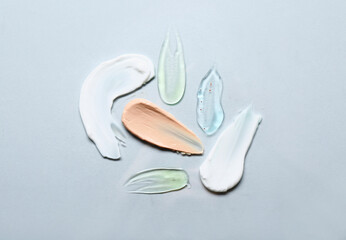 Samples of cosmetic cream with scrub, gel and makeup foundation on white background