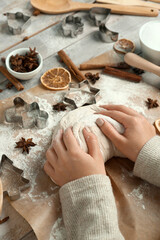 Female hands with raw dough, ingredients and utensils for preparing sweet Christmas cookies on wooden table