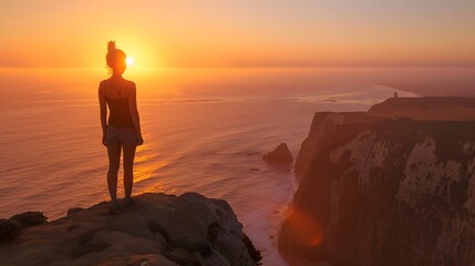 Fototapeta premium This beautiful young girl is posing against a sunset as an example of freedom and healthy living