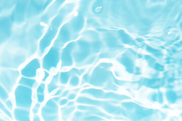 Blue water with ripples on the surface. Defocus blurred transparent blue colored clear calm water surface texture with splashes and bubbles. Water waves with shining pattern texture background.