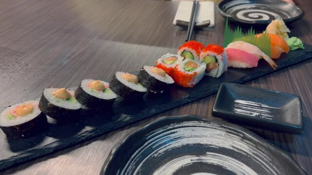 Sushi and rolls in plate. Close-up of sushi rolls on rectangle sushi plate. 