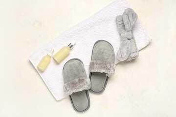 Grey slippers, towel and cosmetic products on white background. Top view