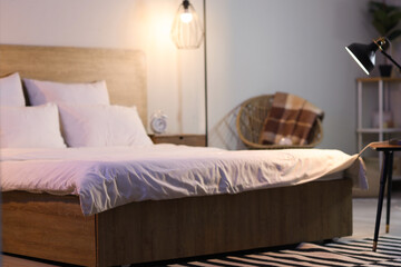 Big bed with pillows in dark bedroom at night