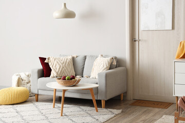 Obraz premium Stylish interior of hall with cozy sofa, chest of drawers and door