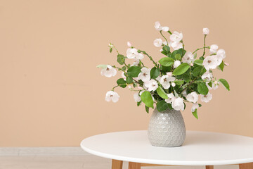 Bouquet of blooming tree branches on coffee table in room, closeup