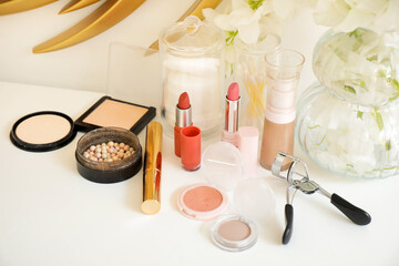 Set of cosmetic products and vase with flowers on table, closeup
