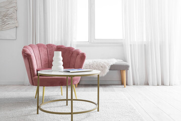 Armchair and coffee table with vase and magazine in living room