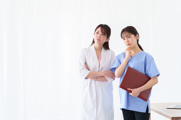 考える女性の医師と看護師