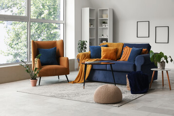 Modern interior of living room with stylish sofa and armchair