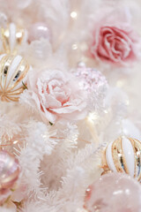 Christmas Festive sparkling background.Christmas Balls,Delicate pink rose and white snowflakes on a blurred beige background. Glowing garlands and Christmas decor.