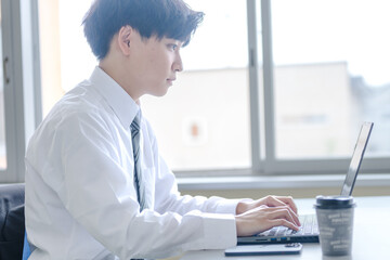 パソコンと爽やかに作業するビジネスマン