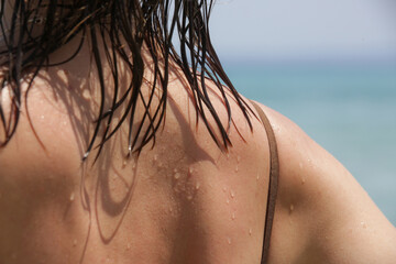 Woman's hair on the beach. Wet hair close up image. Hair damage due to salty ocean water and sun, summertime hair care concept.