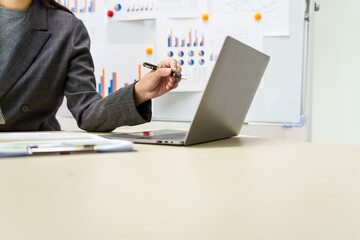 A businesswoman in a grey suit works from home, specializing in policy and planning analysis,...