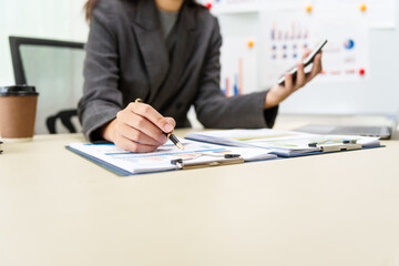 A businesswoman in a grey suit works from home, specializing in policy and planning analysis,...
