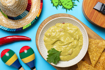 Flat lay composition with Mexican sombrero hat and guacamole on light blue background