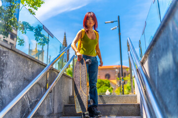 Urban portrait of a chinese young woman holding skateboard outdoors
