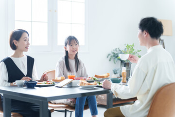 朝食を食べる親子　女の子とお父さん、お母さん