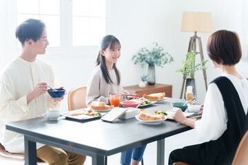 朝食を食べる親子　女の子とお父さん、お母さん