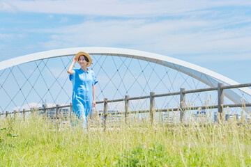 屋外で麦わら帽子をかぶって散歩する女性のポートレート