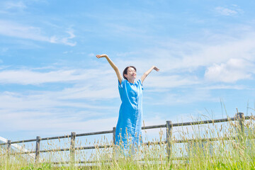 屋外で伸びをする女性