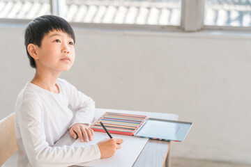 学校・塾の教室で授業を受ける小学校低学年の男の子
