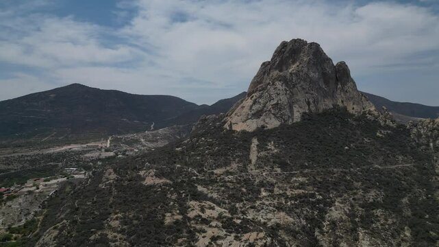 Majestic Pena De Bernal mountain rock formation inQueretaro town below in Mexico.