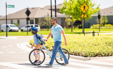 Obraz premium father and son on bicycle at fathers day. active father setting a example for fathers son. fathers parenting with son outdoor. childhood of son supported by fathers care. loving relationship