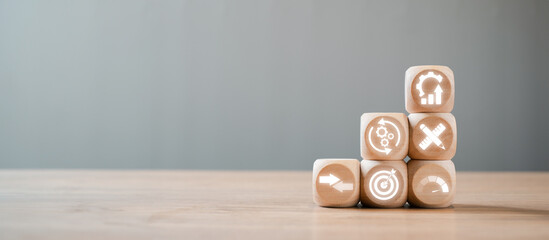 Wooden blocks with business icons stacked in a pyramid shape, symbolizing the benchmarking concept...