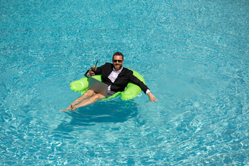 Businessman working on-line outdoor. Travel destinations, summer vacations. Funny business man in suit on summer holiday at sea beach water. Crazy entrepreneur using laptop on vacation.