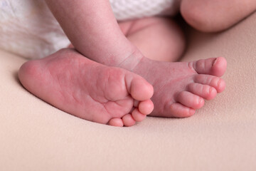 Little newborn baby human feet with toes and toenails close up