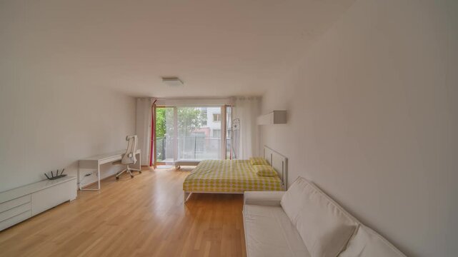 A light-filled studio apartment featuring sophisticated white furniture and a modern kitchen. The open layout increases the spaciousness, creating a perfect urban retreat.