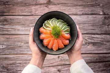 Woman holding a plate of salmon salad,close up image, clean eating fresh salmon and salad vegetable healthy food diet concept.
