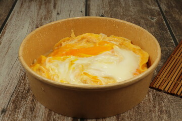 Classic scramble egg serving in the paper box. Famous breakfast delivery menu in Asia. Mock up of frozen food product. High protein and nutrition concept.