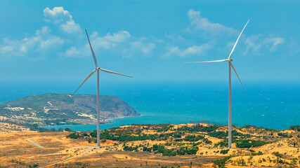 Panoramic view of wind farm or wind park, with high wind turbines for generation electricity with...