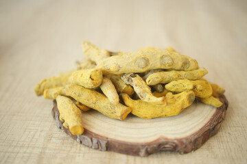 A detailed image captures turmeric roots drying in sunlight, part of the spice production process