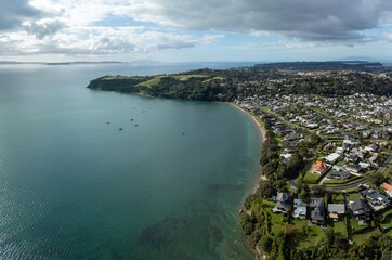 Ocean coastline and residential housing in Tindalls Beach, Whangaparāoa, Auckland, New Zealand.