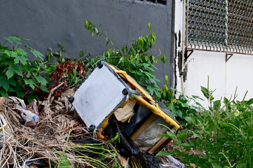 BANGKOK, THAILAND - July 11, 2024: Closeup of dirty old black sofa left on the sidewalk on the street at Thailand. Selective Focus.