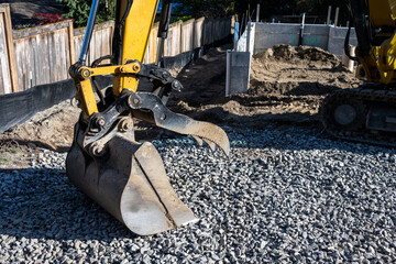 Closeup of heavy equipment Jawbone Bucket with cement foundation of new residential home...