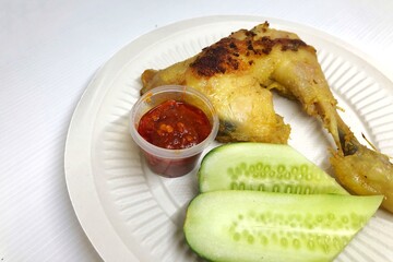 Close-up of fried chicken thighs, cucumber and chili sauce
