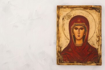 Fototapeta premium Vintage religious icon painting depicting a saint, displayed on a textured white wall with ample copy space.